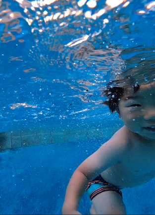 Young boy swims in a pool 